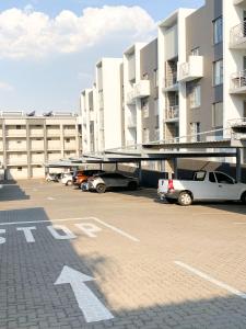 a parking lot with cars parked in front of a building at Simler at Sandton in Johannesburg