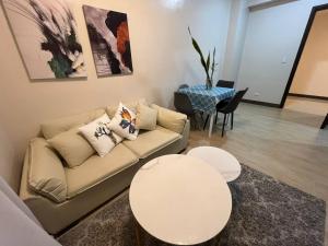 马尼拉GENTRY MANOR fast WiFi,Balcony near Okada,MOA&NAIA 8Q的客厅里有一张沙发和一张桌子。