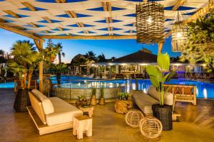 a patio with couches and a pool at night at Avithos Resort Hotel in Svoronata