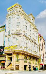 a large white building with a yellow sign on it at Gold Hotel Luxury - Tu Son in Phủ Từ Sơn