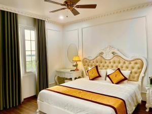 a bedroom with a large bed and a ceiling fan at Gold Hotel Luxury - Tu Son in Phủ Từ Sơn