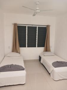 アピアにあるSaolan House Samoaの窓のある部屋にベッドが2つある