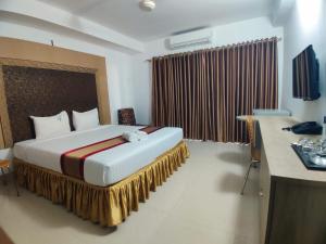 a hotel room with a large bed with a desk at Cox West Inn in Cox's Bazar