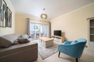 a living room with a couch and a chair at Cabanas de Tavira Family Apartment in Cabanas de Tavira