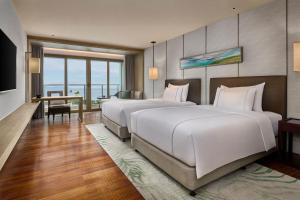 Voodi või voodid majutusasutuse Shenzhen Dameisha Kingkey Palace Hotel toas