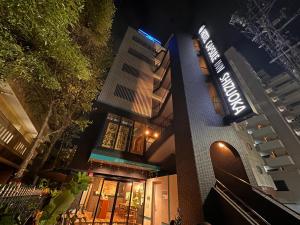 静岡市にあるホテルカプセルイン静岡の夜間の看板付きの建物