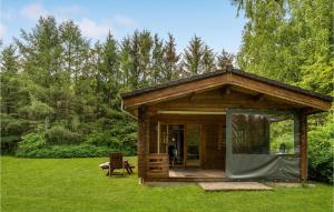a small wooden cabin in a field with trees at Two-Bedroom Holiday Home In Herning in Herning +12 photos