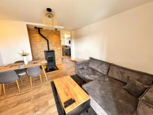 a living room with a couch and a table at Les Rousses Du Lac in Les Rousses
