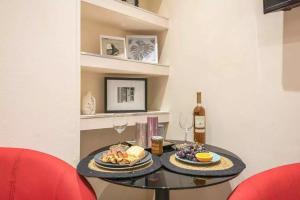 a table with two plates of food and wine glasses at Elegant Escape Kolonaki in Athens +9 photos