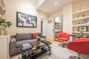 a living room with a couch and a red chair at Elegant Escape Kolonaki in Athens