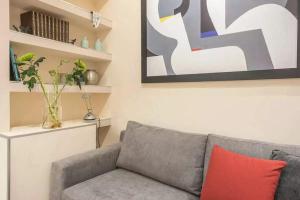 a living room with a gray couch with a red pillow at Elegant Escape Kolonaki in Athens