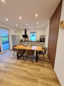 Una cocina y un comedor con mesa y sillas de madera. en Ferienhaus Alex, en Gönnersdorf