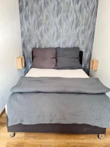 1 cama con cabecero gris en un dormitorio en Ferienhaus Alex, en Gönnersdorf