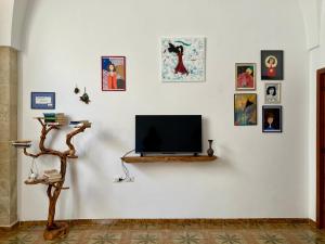 ガラティーナにあるCasArteの白い壁に絵画を飾った薄型テレビ