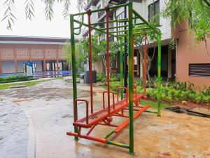 a playground with orange and green equipment in front of a building at Cozy 3BR Asatti Apartment near ICE BSD By Travelio in Tangerang