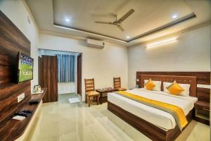 a hotel room with a bed and a television at Hotel Visa Inn 4kms from Airport l Free Airport pickup & drop 24x7 in Bengaluru