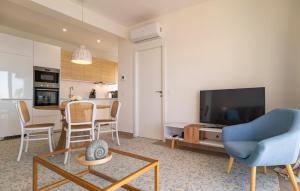 a living room with a blue chair and a tv at Stunning Apartment In Almuñecar in Almuñécar