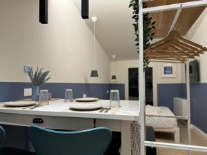 a dining room with a white table and blue chairs at Appartamento Magritte in Brescia