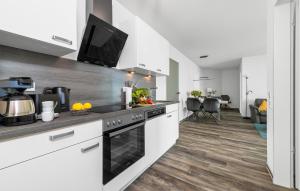 una cucina con elettrodomestici bianchi e un soggiorno di Ostseetraum 307 a Olpenitz