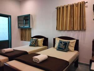 three beds in a room with curtains at Fort Kochi Paradise Homestay in Fort Kochi