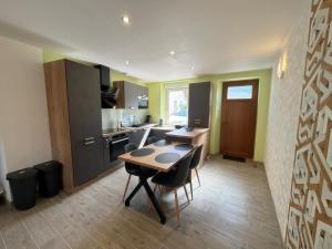 a kitchen with a table and chairs in a room at Le Domaine de L étang La saboterie in Oeuilly