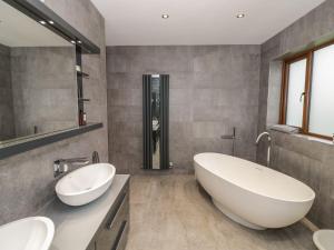 a bathroom with two sinks and a large tub at 85A Braybrooke Road in Kettering +41 photos