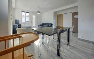 ein Esszimmer mit Glastisch und Stühlen in der Unterkunft 4 Bedroom Awesome Home In Royan in Royan