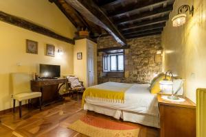 a bedroom with a bed and a desk and a television at La Casona De Barrio in Barrio