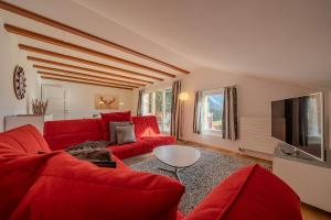 Una sala de estar con un sofá rojo y un televisor. en Sans Souci OG by Arosa Stay, en Arosa