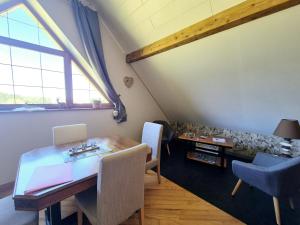 a dining room with a table and a couch at Gîte Le Bijou et Spa in Weiterswiller