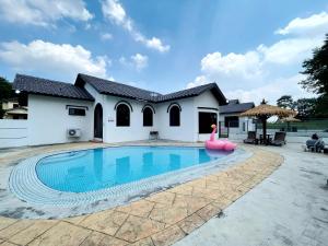 una piscina davanti a una casa di A'FAMOSA Pool Villa by S&T Homez ad Alor Gajah