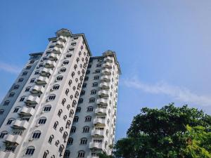 een hoog wit gebouw met balkons en een boom bij Casuarina Lot-1103 Malacca in Melaka