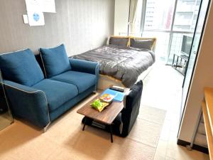 a living room with a couch and a bed and a table at lineweb Home sapporo803 in Sapporo