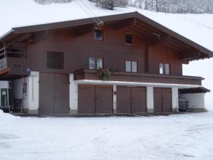 a house with two garage doors in the snow at Löschenbrandhof in Mittersill +15 photos