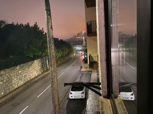dos autos blancos estacionados al lado de una calle en Studio Leiria City - NSA-T0, en Arrabalde da Ponte