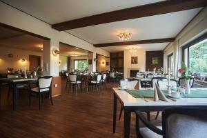 a restaurant with tables and chairs in a room at Hotel Restaurant Waldschlößchen in Lienen