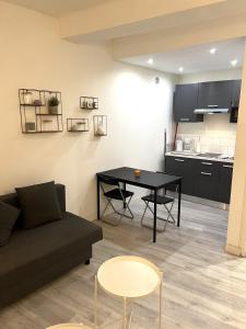 a living room with a couch and a table at La Ciotat Chez Hugo confortable studio clim, wifi, parking, centre ville, commerces, port, plages à pieds in La Ciotat