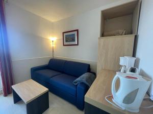 Una sala de estar con un sofá azul y un televisor. en LE GRAND BLEU-Fouc, en Le Barcarès