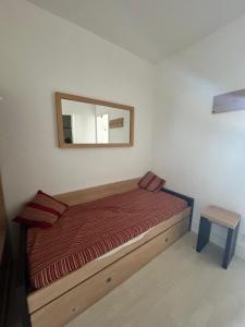 Un dormitorio pequeño con una cama y un espejo. en LE GRAND BLEU-Fouc, en Le Barcarès