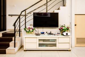 バターワースにあるValue Inn Homestay by uBookのリビングルームのドレッサー上部のテレビ