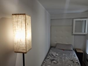 a small bedroom with a bed and a lamp at Gibraltar Sun Poolside Escape in Gibraltar