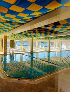 a swimming pool with a blue and yellow ceiling at Ferienwohnung Wolkenfrei mit Pool und Sauna in Scheidegg