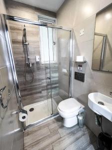 a bathroom with a shower and a toilet and a sink at Napoli Suites Studios Aparthotel in St Julian's +97 photos