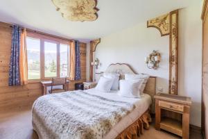 a bedroom with a large bed and a window at La Maison Hôtel Les Peupliers in Courchevel