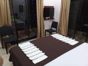 a bedroom with a bed with white pillows on it at Hotel Town Pride , Ganpatipule in Ganpatipule