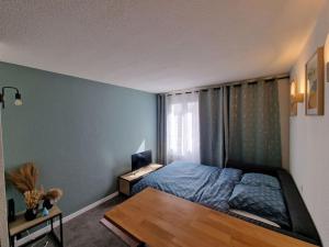 a bedroom with a bed and a wooden table at Joli studio Disneyland Paris 2 pers in Bussy-Saint-Georges