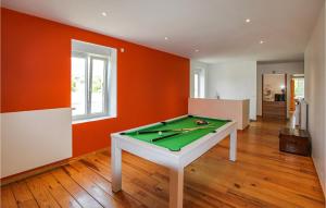 a pool table in a room with an orange wall at Beautiful Home In Sauzet in Sauzet