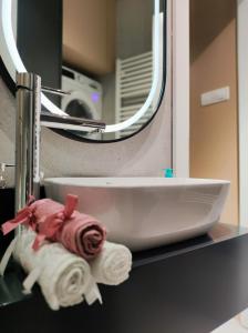 a bathroom sink with a towel and a mirror at Deluxe Rezidencija Bijeljina in Bijeljina +29 photos