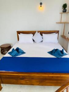 Una cama azul y blanca con almohadas azules. en Kumudu Holiday Home, en Hiriketiya