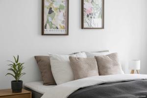 a bedroom with a bed with three pictures on the wall at Premium High-Street Home w Large Private Terrace in Aarhus +40 photos